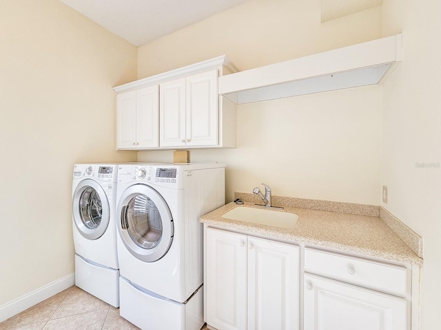 clothes washing area featuring light tile patterned flooring, cabinets, washer and clothes dryer, and sink