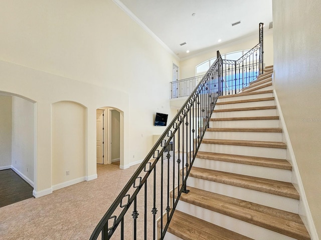 stairway featuring ornamental molding and tile patterned floors