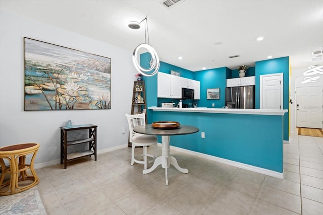 kitchen with decorative light fixtures, stainless steel fridge, and white cabinetry