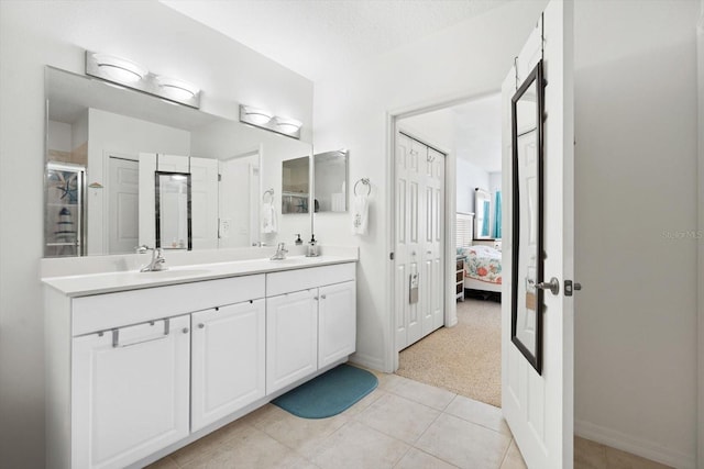 bathroom with a textured ceiling, tile patterned flooring, an enclosed shower, and vanity