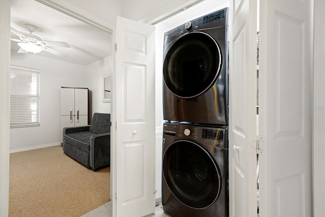 washroom featuring a textured ceiling, ceiling fan, and stacked washer and clothes dryer