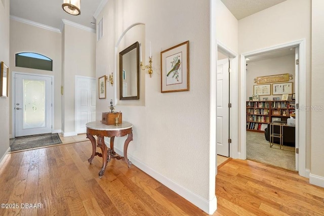 foyer featuring light hardwood / wood-style flooring and crown molding