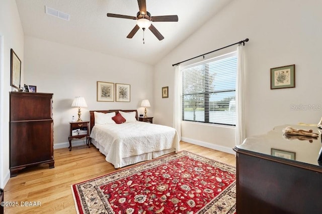 bedroom with ceiling fan, light hardwood / wood-style flooring, and lofted ceiling