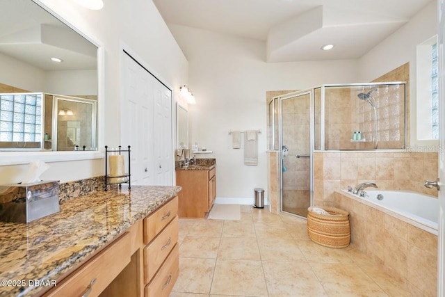 bathroom with tile patterned flooring, independent shower and bath, and vanity