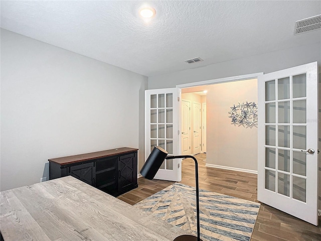 bedroom featuring a textured ceiling and french doors