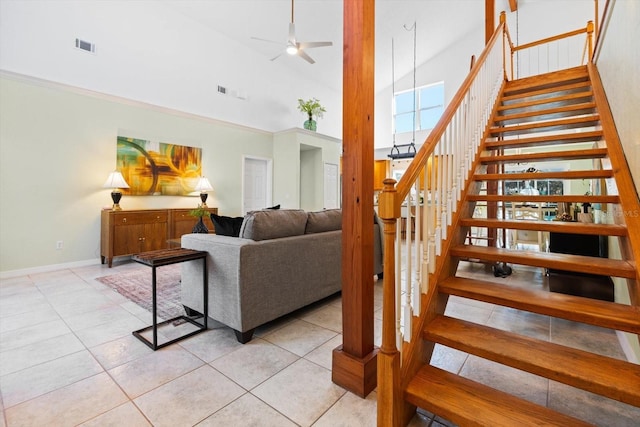 stairway with high vaulted ceiling, ceiling fan, and tile patterned floors