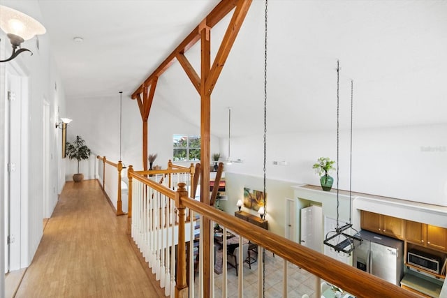 hall featuring lofted ceiling and light wood-type flooring