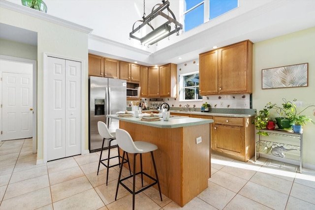 kitchen featuring sink, appliances with stainless steel finishes, light tile patterned flooring, and a kitchen island