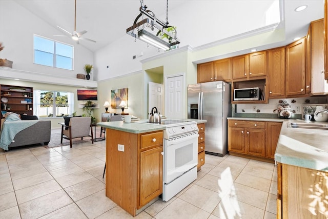 kitchen with light tile patterned floors, stainless steel appliances, a center island with sink, and sink