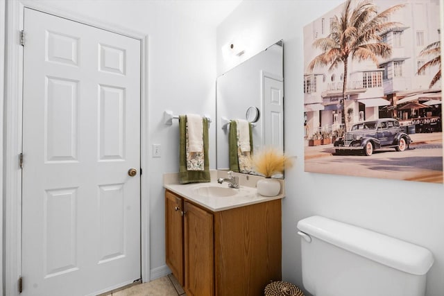 bathroom with toilet, vanity, and tile patterned floors