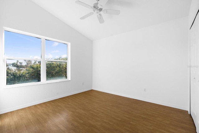 empty room featuring dark wood-type flooring, lofted ceiling, and ceiling fan