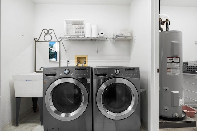 laundry room featuring washer and dryer, tile patterned floors, and electric water heater