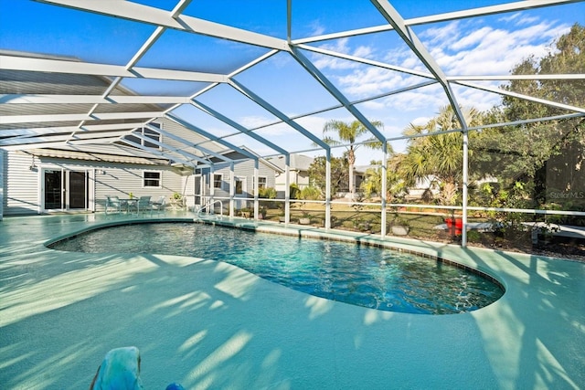 view of swimming pool with glass enclosure and a patio area