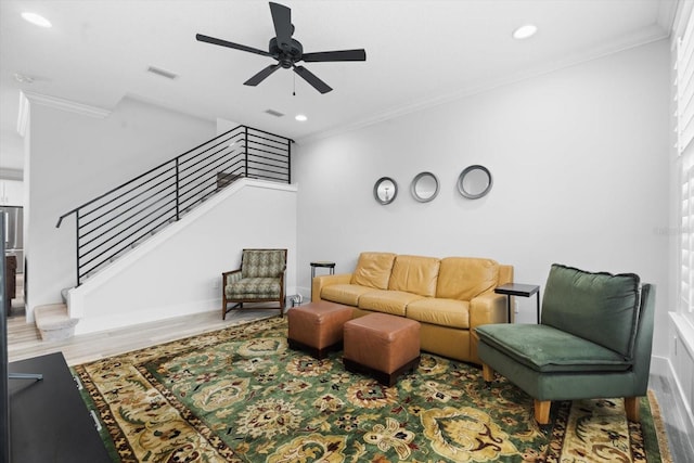 living room featuring hardwood / wood-style floors, ceiling fan, and crown molding