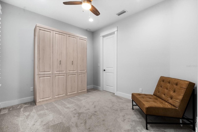 sitting room featuring light carpet and ceiling fan