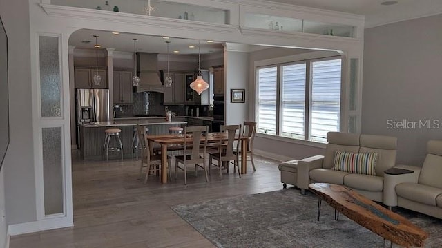 dining area with ornamental molding and wood-type flooring