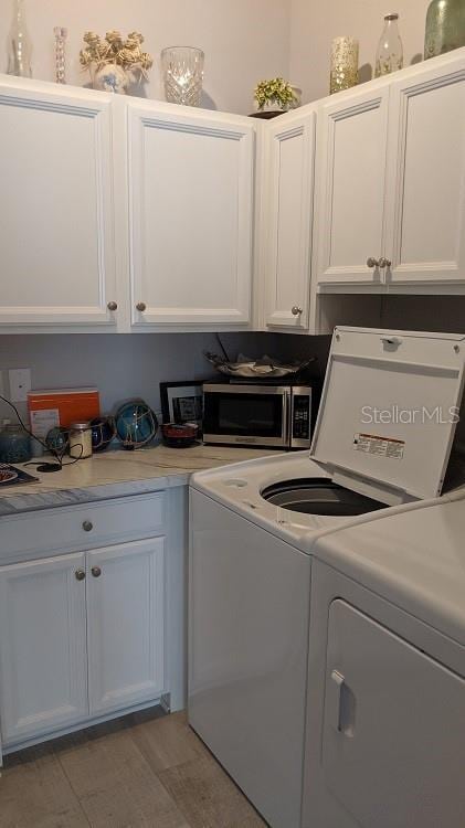 laundry area featuring independent washer and dryer and cabinets