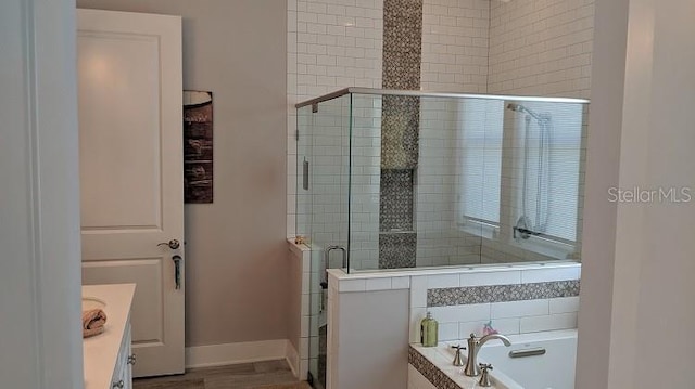 bathroom with vanity and shower with separate bathtub