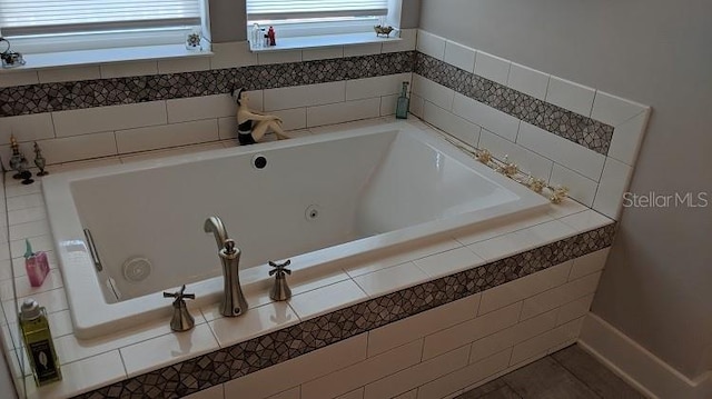 bathroom featuring tile patterned flooring and a relaxing tiled tub