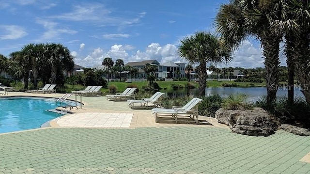 view of swimming pool featuring a patio and a water view