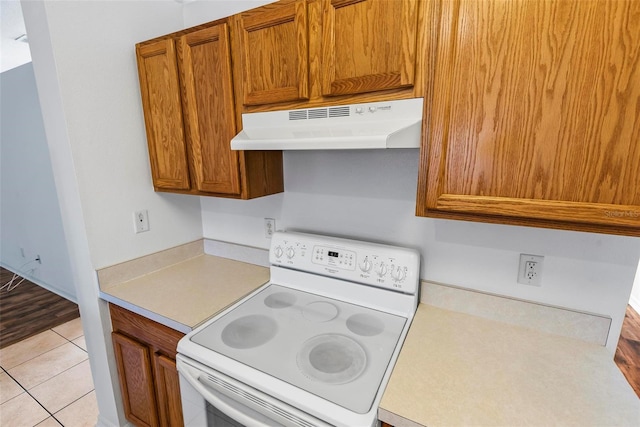 kitchen with white electric stove and light tile patterned floors