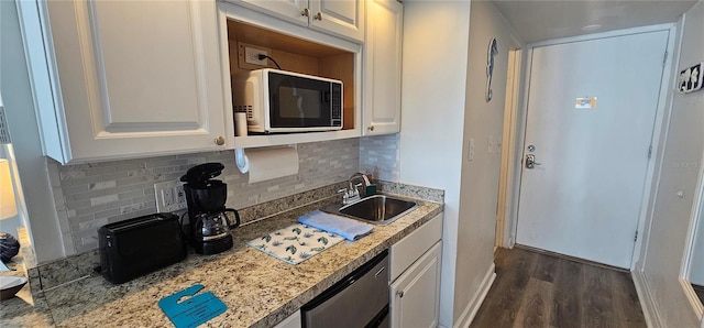 kitchen featuring white cabinets, dishwasher, backsplash, and sink