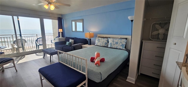 bedroom featuring ceiling fan, a water view, and hardwood / wood-style flooring