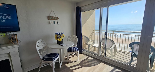 dining room with a beach view, a water view, and wood-type flooring