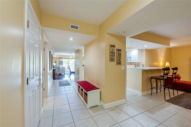 hall featuring light tile patterned flooring