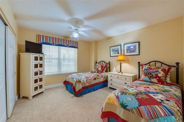 bedroom featuring ceiling fan, a closet, and light carpet