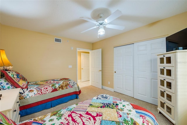 bedroom with ceiling fan, a closet, and light carpet