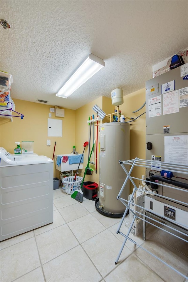 laundry area featuring tile patterned flooring, washer and dryer, electric water heater, and a textured ceiling