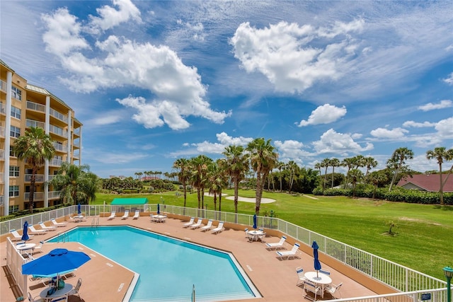 view of pool with a lawn and a patio