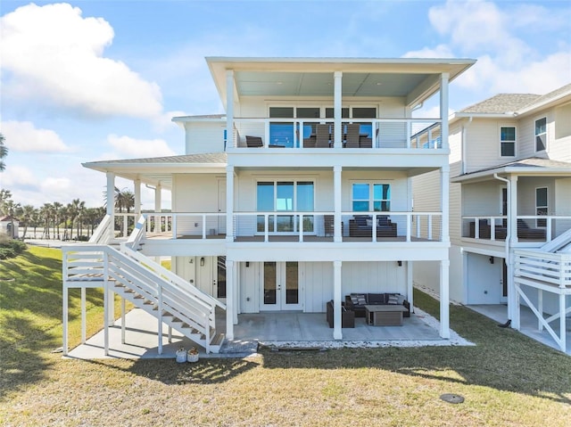 rear view of house featuring a patio area, a yard, outdoor lounge area, french doors, and a balcony