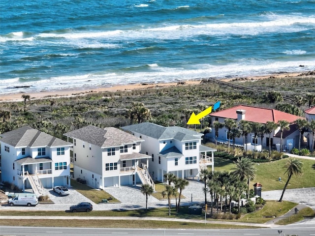 drone / aerial view featuring a beach view and a water view