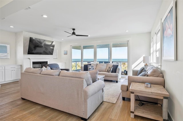 living room featuring ceiling fan and light hardwood / wood-style flooring