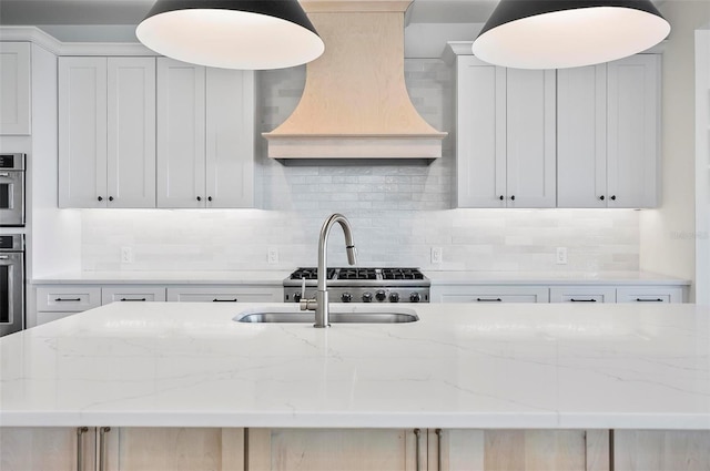 kitchen with stainless steel oven, light stone countertops, custom range hood, and white cabinets