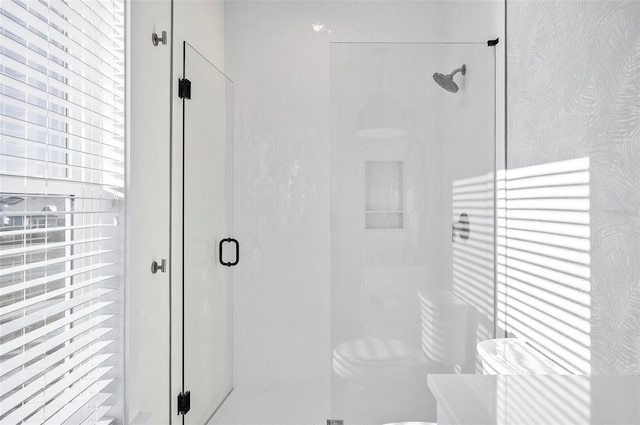 bathroom with a shower with door and toilet