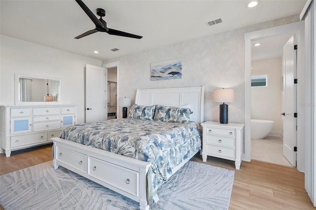 bedroom featuring ceiling fan, ensuite bathroom, and light hardwood / wood-style floors