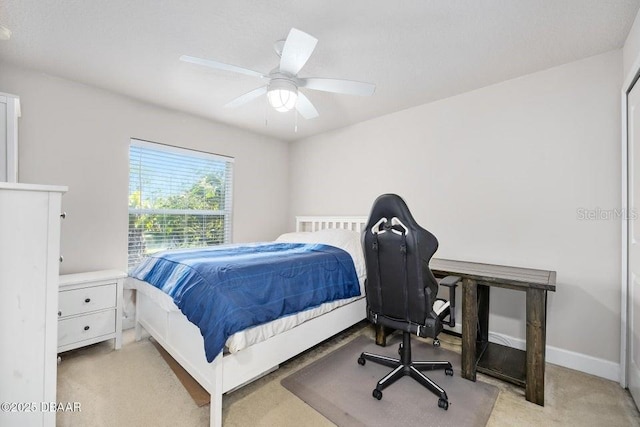 bedroom with ceiling fan and light carpet