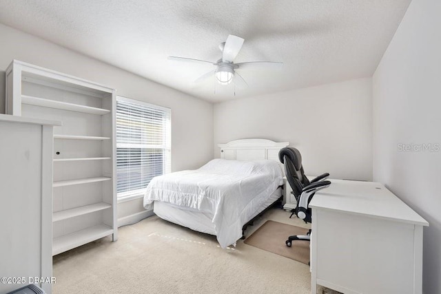 carpeted bedroom featuring a textured ceiling and ceiling fan