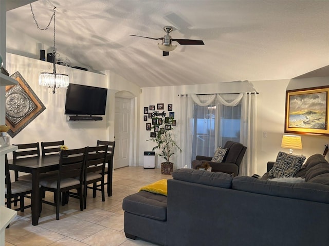 living room featuring a textured ceiling, light tile patterned flooring, lofted ceiling, and ceiling fan with notable chandelier