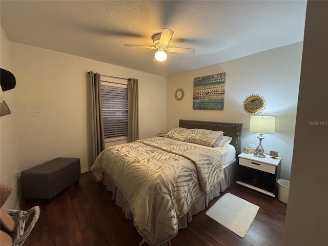 bedroom with a textured ceiling, ceiling fan, and dark hardwood / wood-style floors