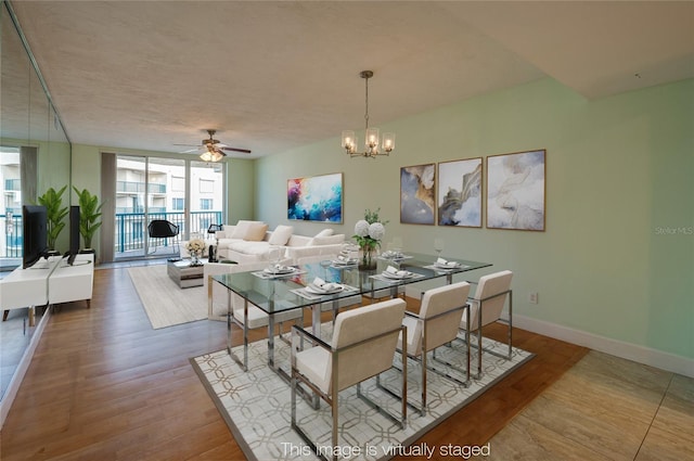 dining room featuring floor to ceiling windows, ceiling fan with notable chandelier, and hardwood / wood-style floors