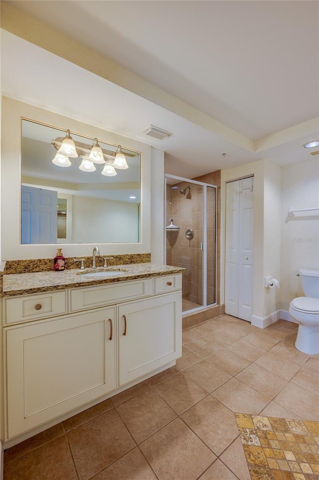 bathroom featuring toilet, tile patterned flooring, a shower with shower door, and vanity