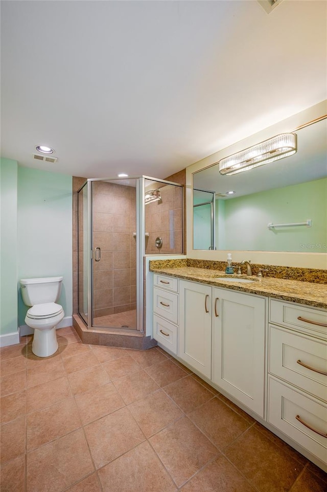 bathroom featuring tile patterned floors, walk in shower, vanity, and toilet