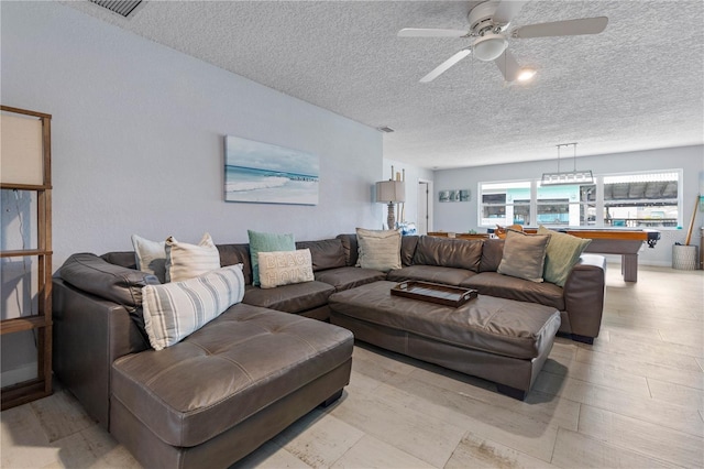 living room with a textured ceiling, ceiling fan, and pool table