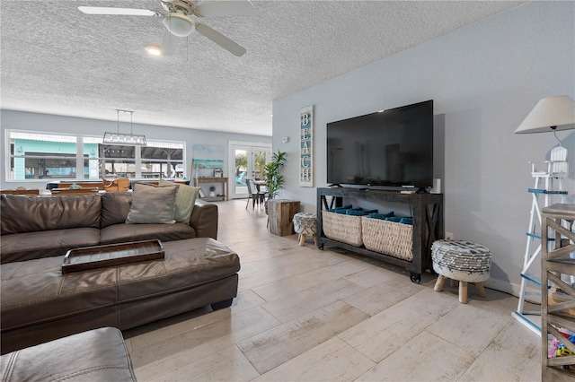 living room with ceiling fan, a textured ceiling, and french doors