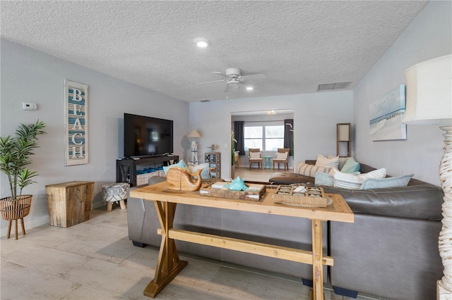 living room with ceiling fan and a textured ceiling