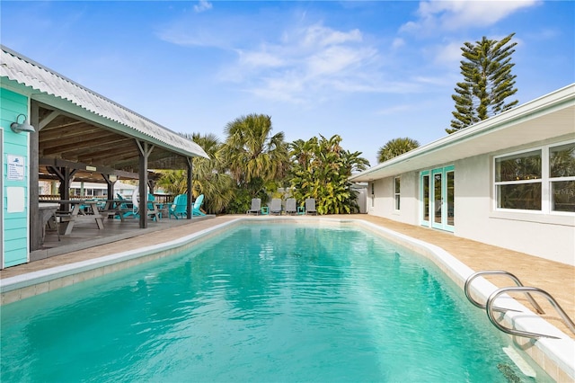 view of swimming pool featuring a patio area and french doors